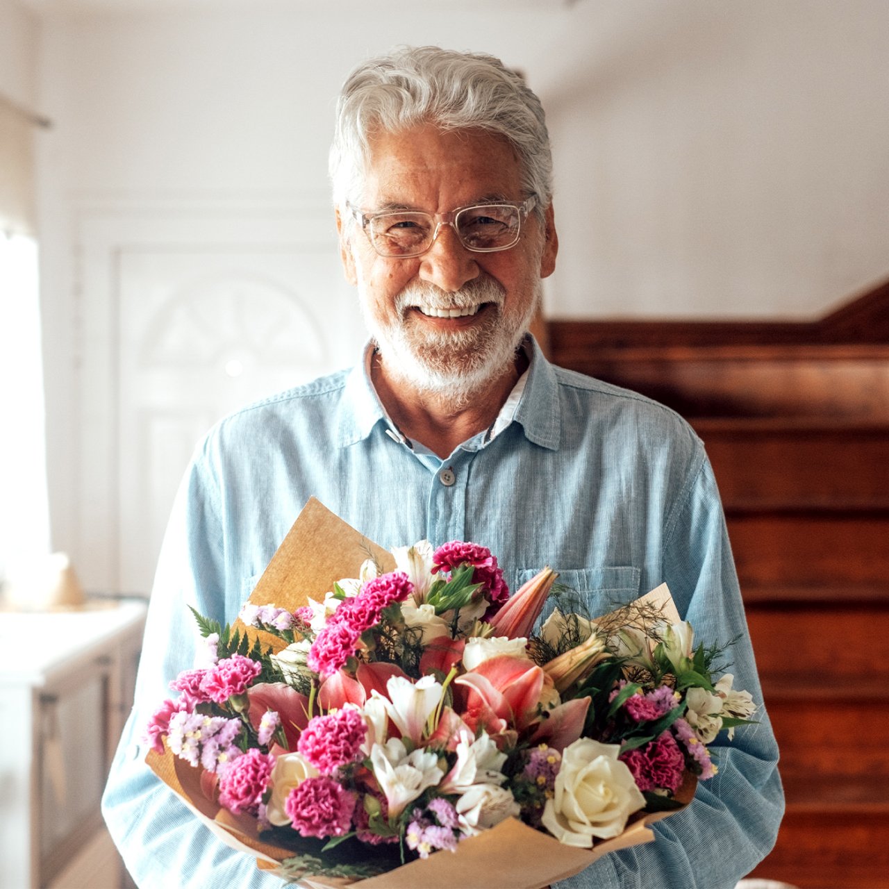 Mann freut sich über eine Blumenstrass von Fleurop